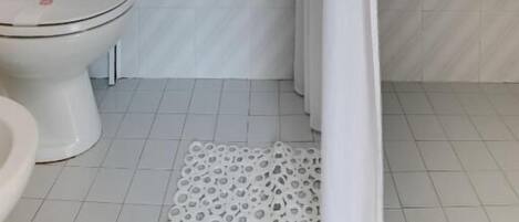 Un baño con ducha, inodoro y lavabo.