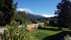 A pathway leading to a building with a mountain backdrop. - Apartments Winkler (Bad Goisern)