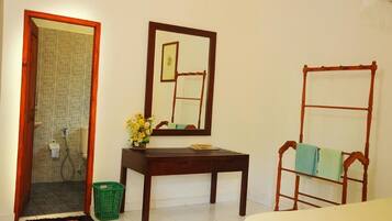 A bathroom with a shower, a mirror, a wooden bench, and a green basket.