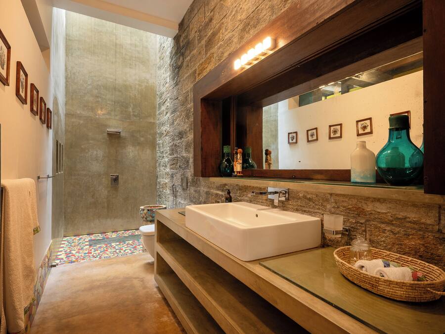 Un baño moderno con un lavamanos grande, un espejo y una zona de ducha.
