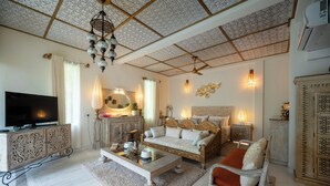 Una sala de estar con sofá, sillón y televisor.