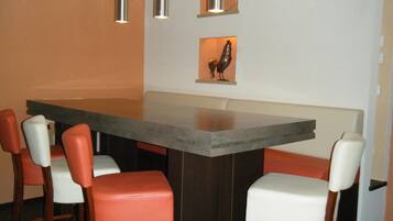 A modern dining area with a rectangular table, four chairs, and pendant lights.