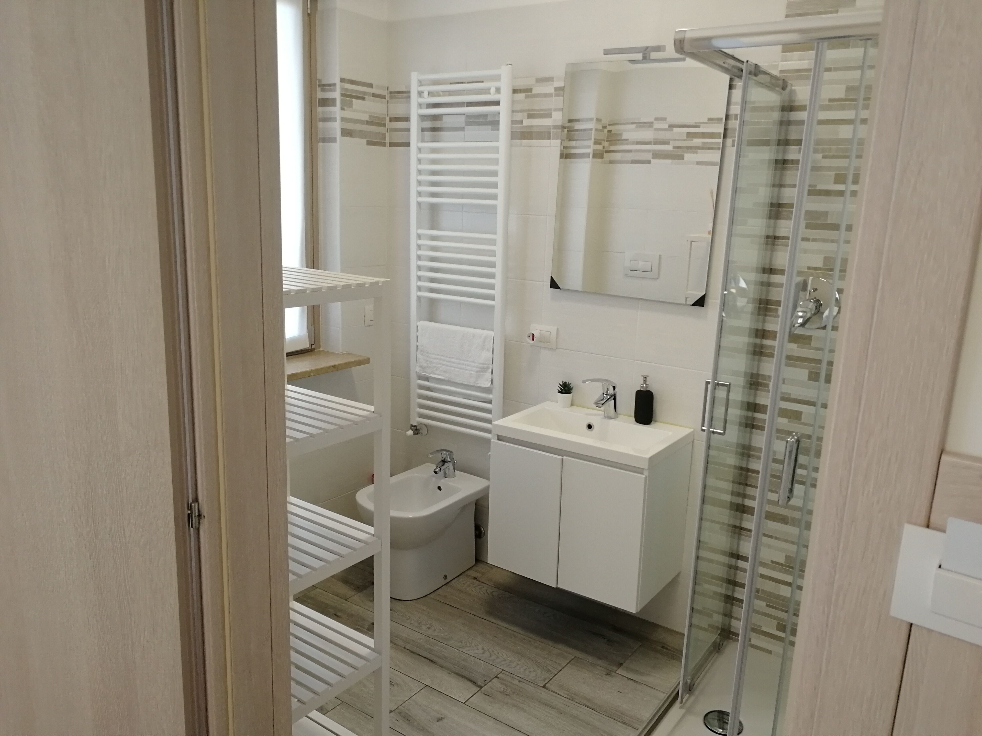 Ein modernes Badezimmer mit Glasdusche, weißem Waschbecken und Toilette.