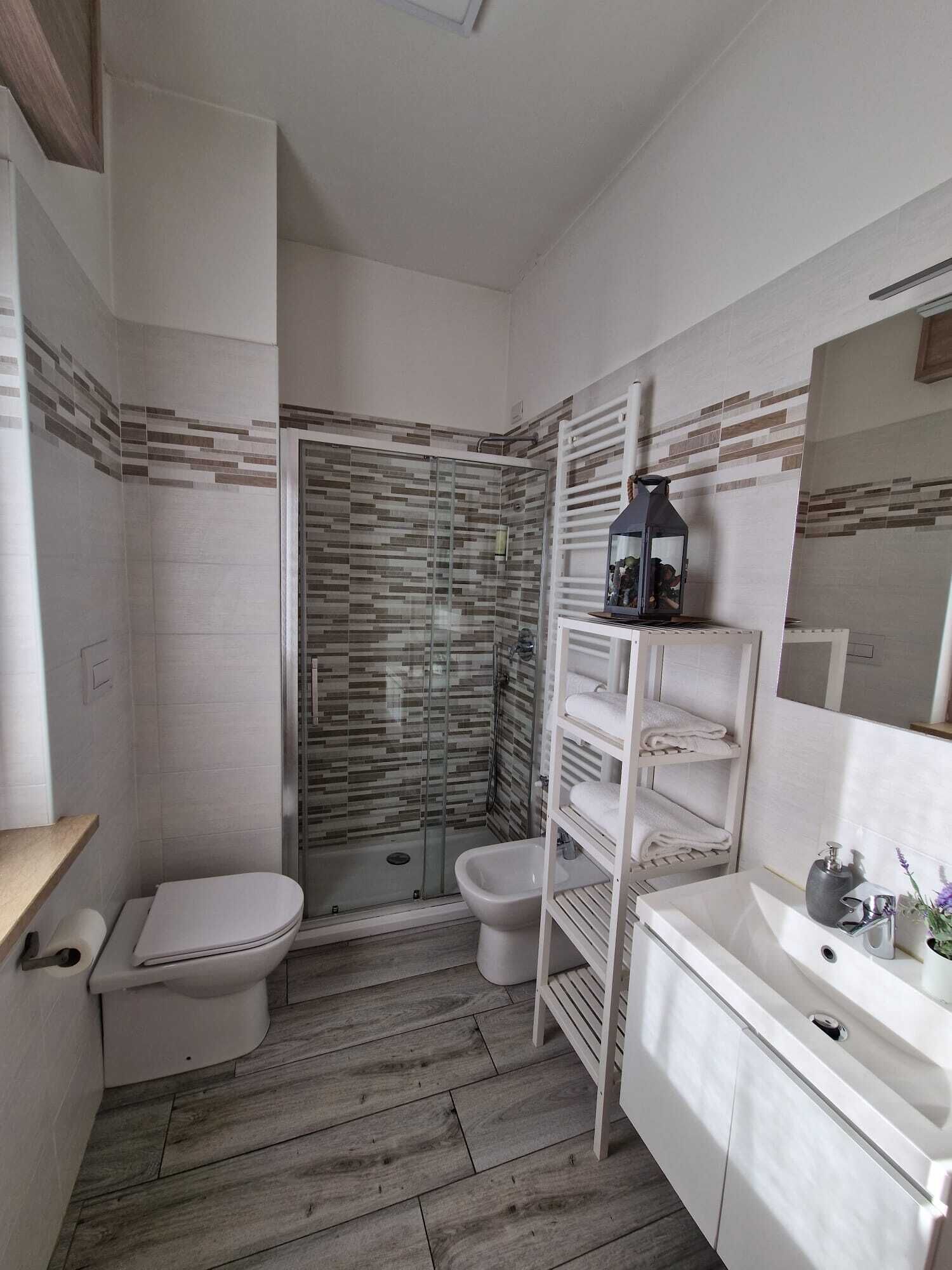 A bathroom with a shower, toilet, and sink.