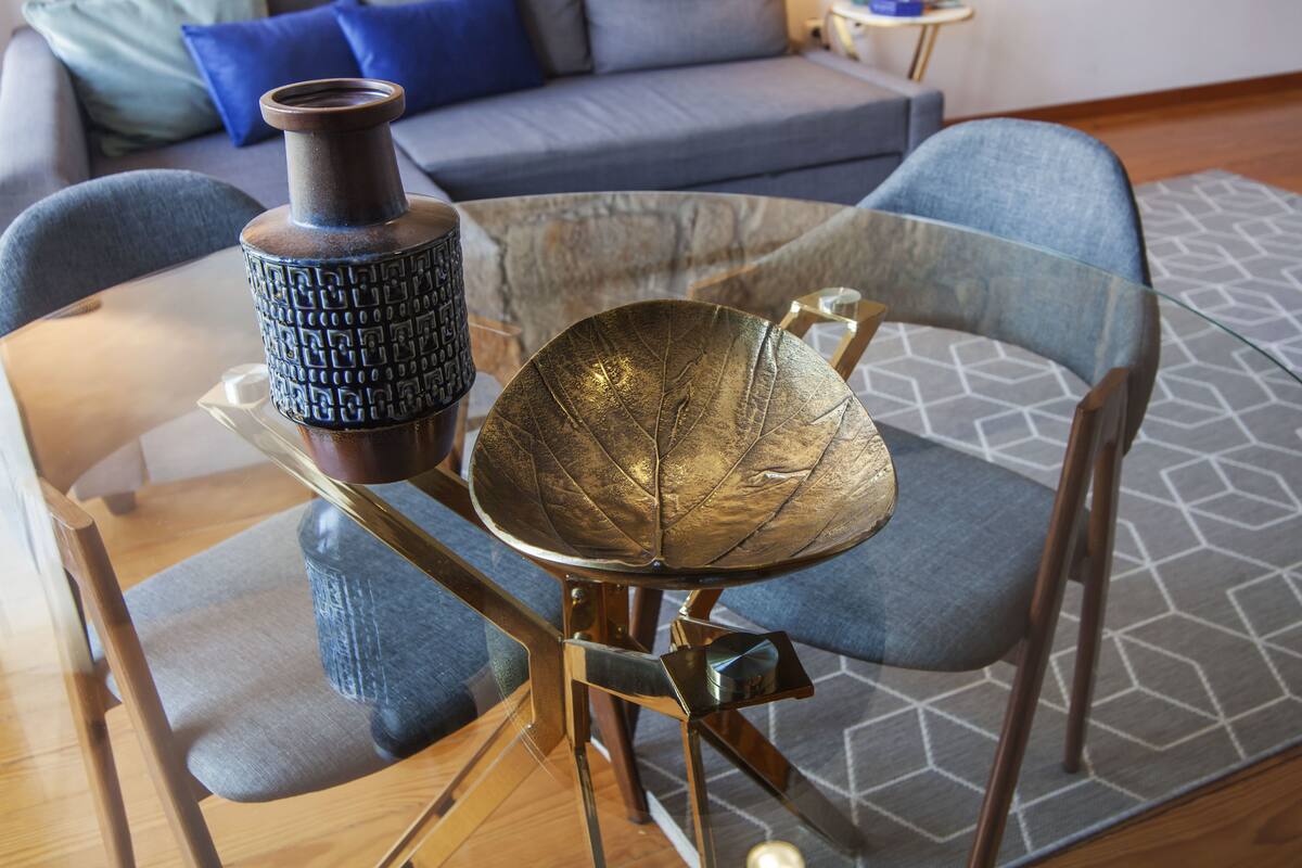 Une table à manger avec des chaises, un vase et un bol décoratif.