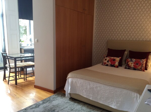 A bedroom with a bed, a desk, and a chair.