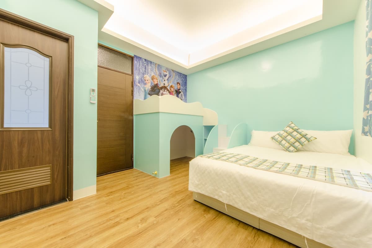 A bedroom with a bunk bed, a door with a frosted glass panel, a wall mural, and a ceiling light.