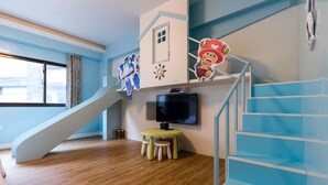 A modern room with a wooden floor, a yellow table with stools, a TV, a staircase, and a window with curtains. - DAN DAN Bed and breakfast (Dongshan)