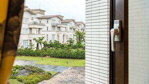 A view of a residential building with multiple balconies and a well-maintained garden. - DAN DAN Bed and breakfast (Dongshan)