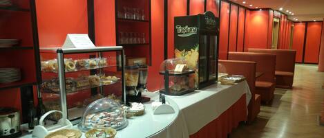A buffet setup with various food items and a coffee station.