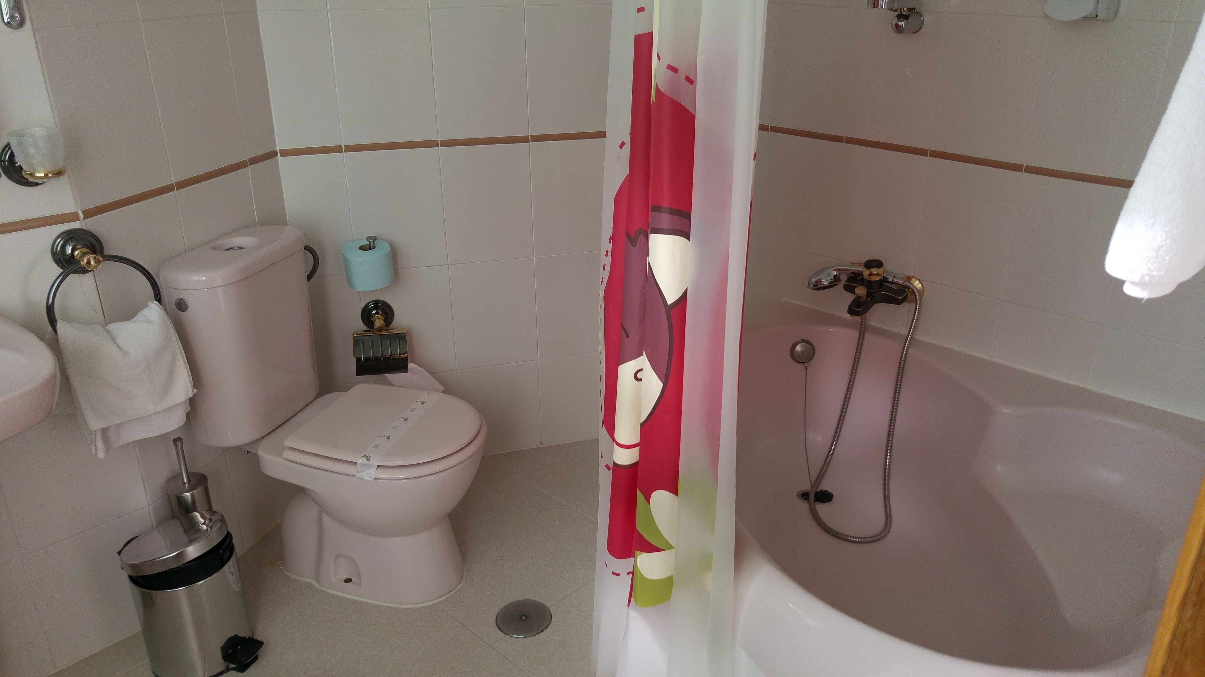 Kylpyhuone, jossa on wc, pesuallas ja kylpyamme.