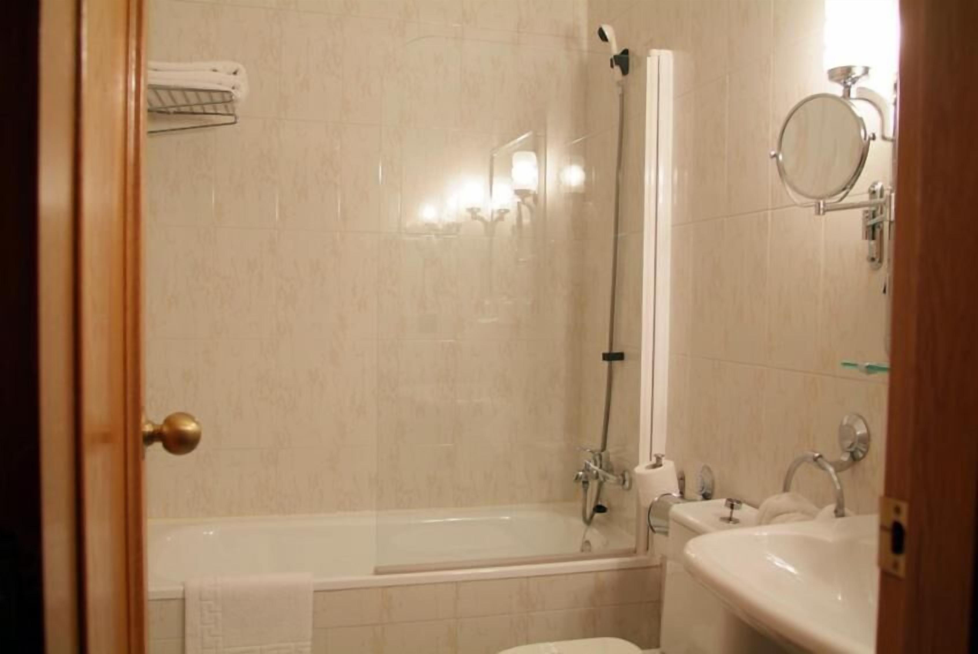 A bathroom with a bathtub, a shower, and a sink.