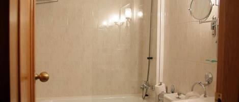 A bathroom with a bathtub, a shower, and a sink.