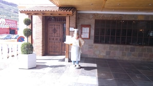 Un ristorante con facciata in pietra, porta in legno e insegna.