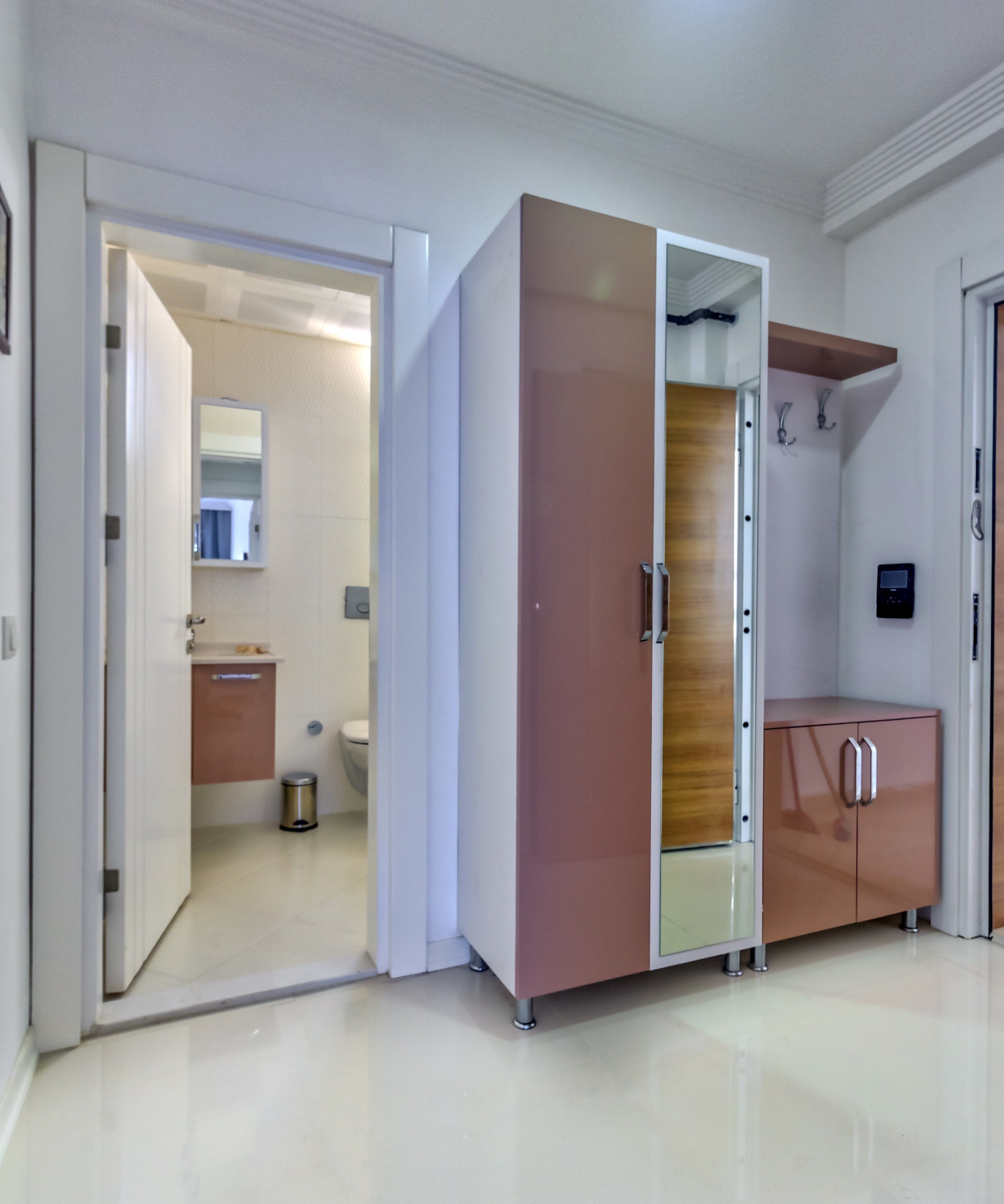 A modern room with a wardrobe, a mirror, and a small cabinet.