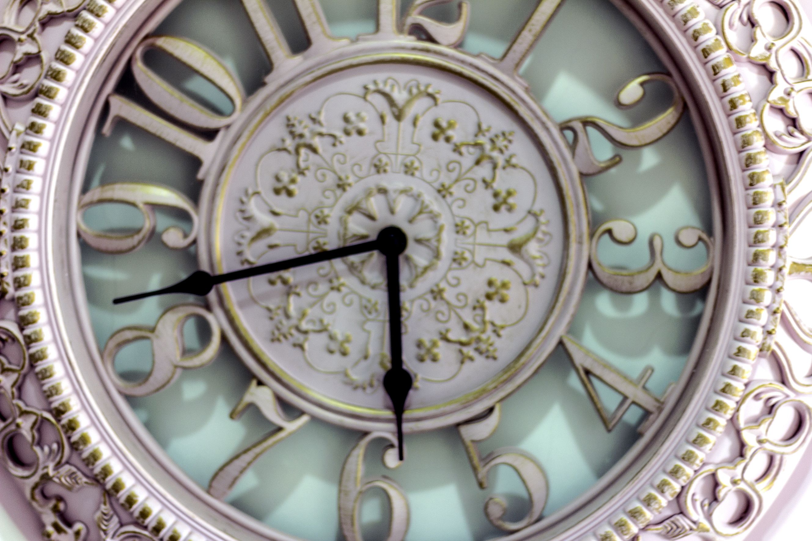 Un reloj con diseños ornamentales y un fondo azul claro.