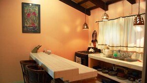 A kitchen with a long counter, hanging lights, and a painting on the wall. - Casita Bendon by Las Palmas (Bucerías)