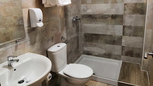 Un baño con ducha, inodoro y lavamanos.