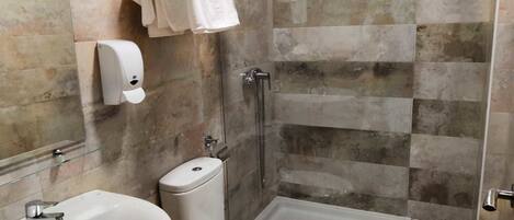 A bathroom with a shower, toilet, and sink.