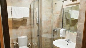 Un baño moderno con ducha de vidrio, inodoro y lavamanos.