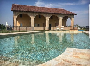 Una piscina al aire libre de temporada, sillones reclinables de piscina