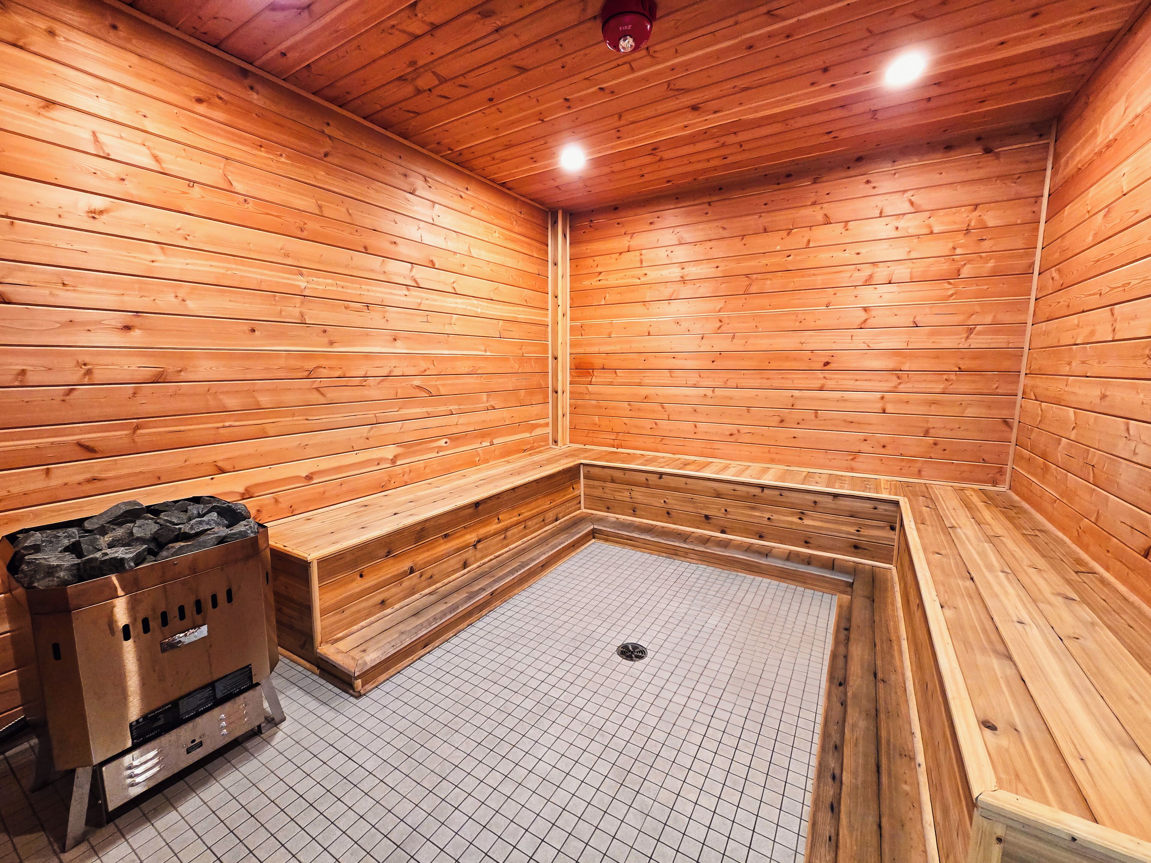 A sauna room with wooden walls and a bench.