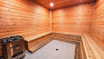 A sauna room with wooden walls and a bench.