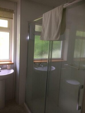 A bathroom with a glass shower enclosure, a sink, and a window. - Old Springwell Croft (Fort William)