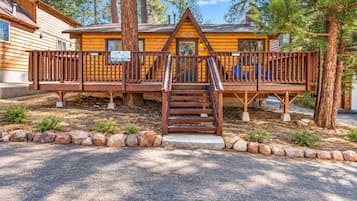 Een chalet met een houten terras, een trap en een bordje met de tekst 'cool chalet'.