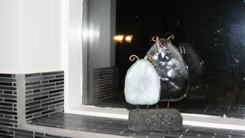 Ein Fenster mit einem dekorativen Glasornament, das zwei kugelförmige Formen und eine kleine Basis zeigt.