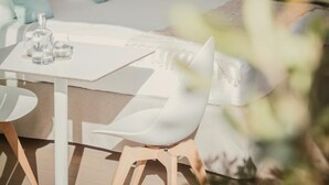 Une chambre moderne dotée d’une grande fenêtre, d’une tête de lit en bois et d’une douche en verre.