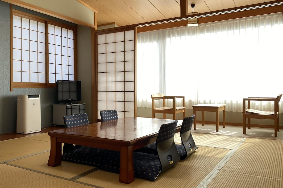A traditional Japanese-style room with tatami flooring, a low table, and shoji screens.