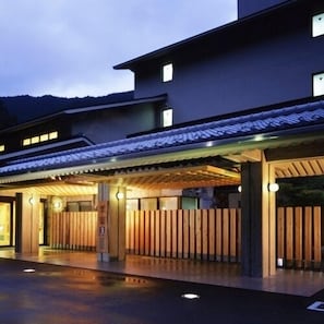 A modern building with a traditional entrance, a covered walkway, and a wooden fence. - Ryujin Onsen Kirari Ryujin (Tanabe)