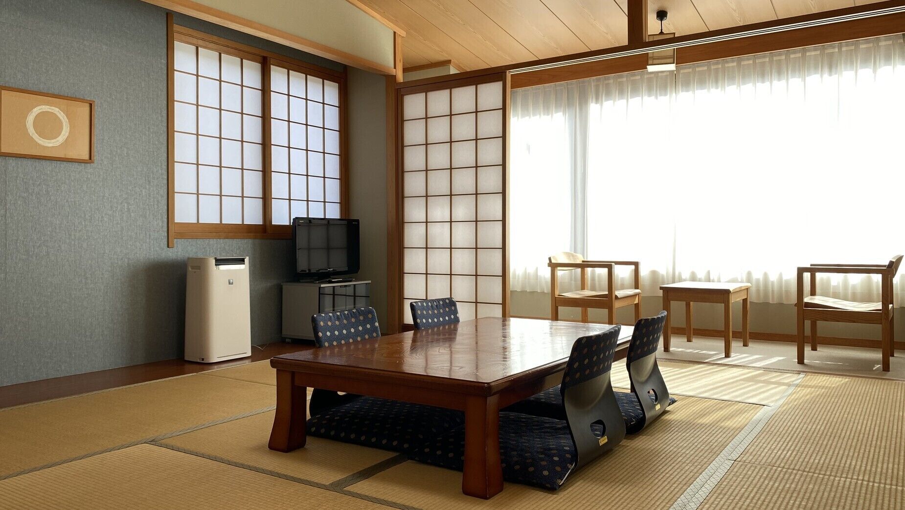 Una habitación tradicional japonesa con suelo de tatami, una mesita baja y puertas correderas de papel.