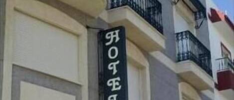 A hotel facade with a sign reading "HOTEL".