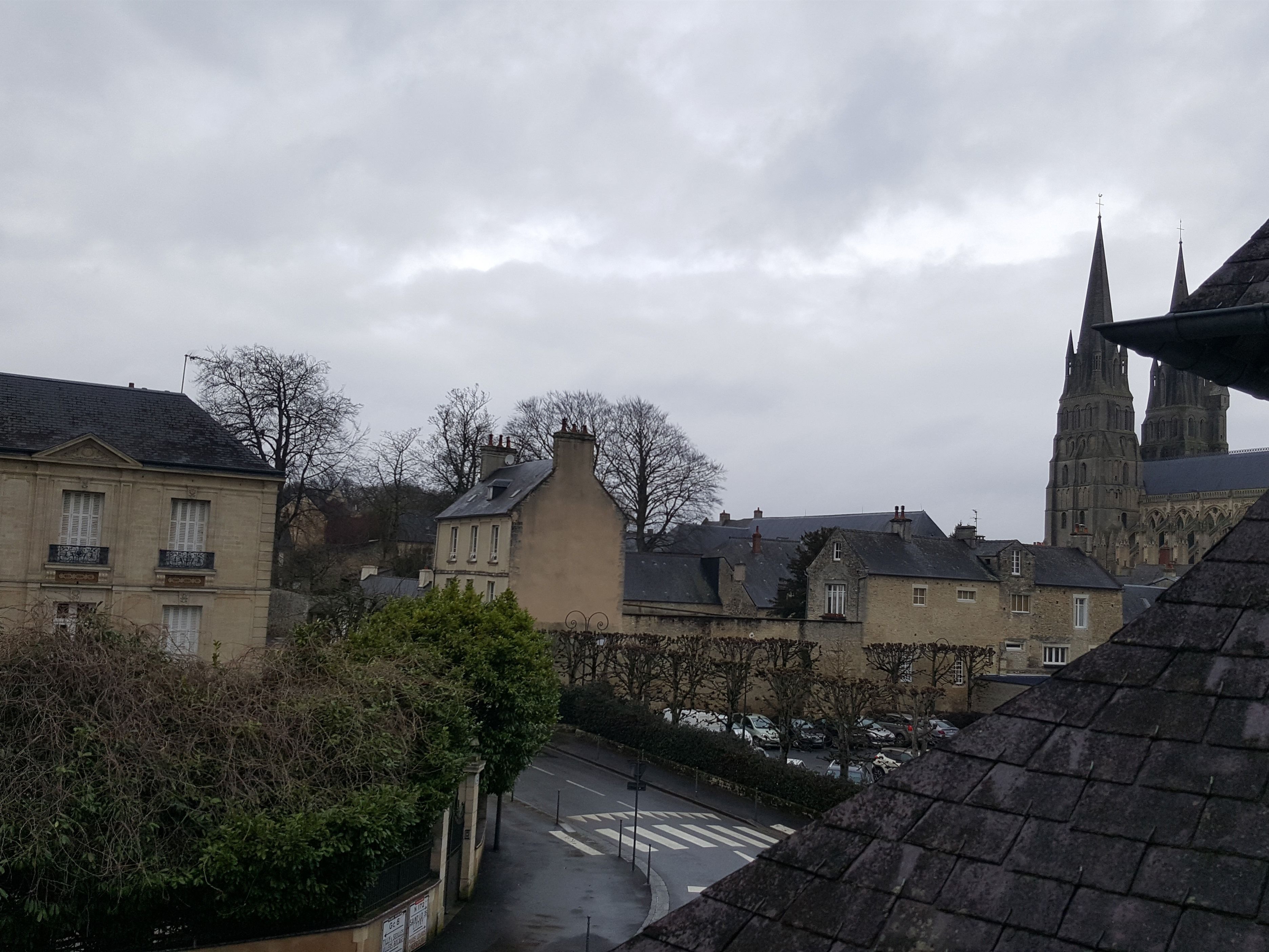 Vista de una calle con edificios, incluyendo una iglesia con dos torres y un paso de peatones.