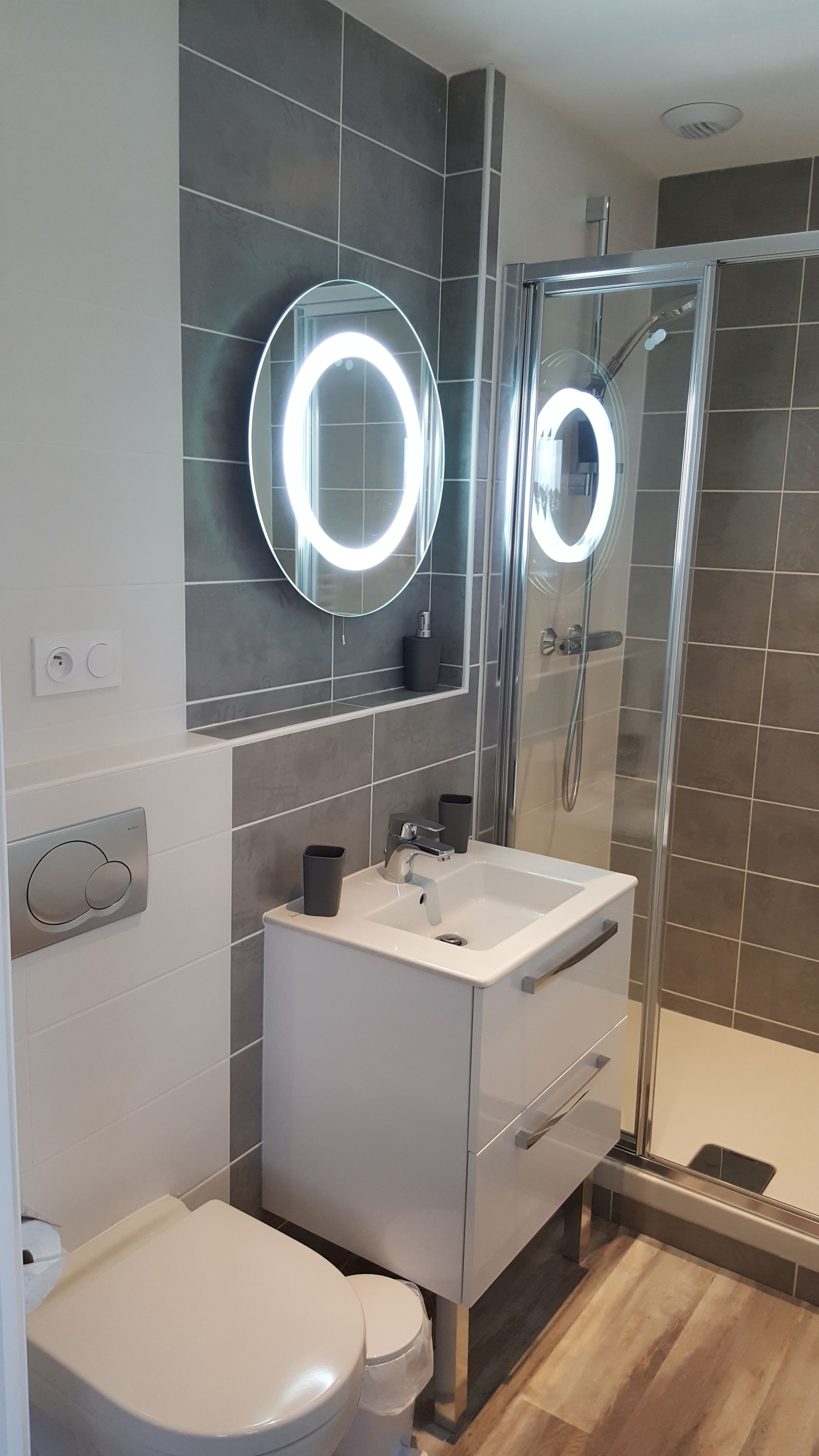 A modern bathroom with a toilet, sink, and shower.
