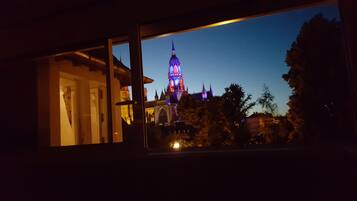 Une vue d’un bâtiment doté d’une tour imposante, qui pourrait être un hôtel, prise à travers une fenêtre.