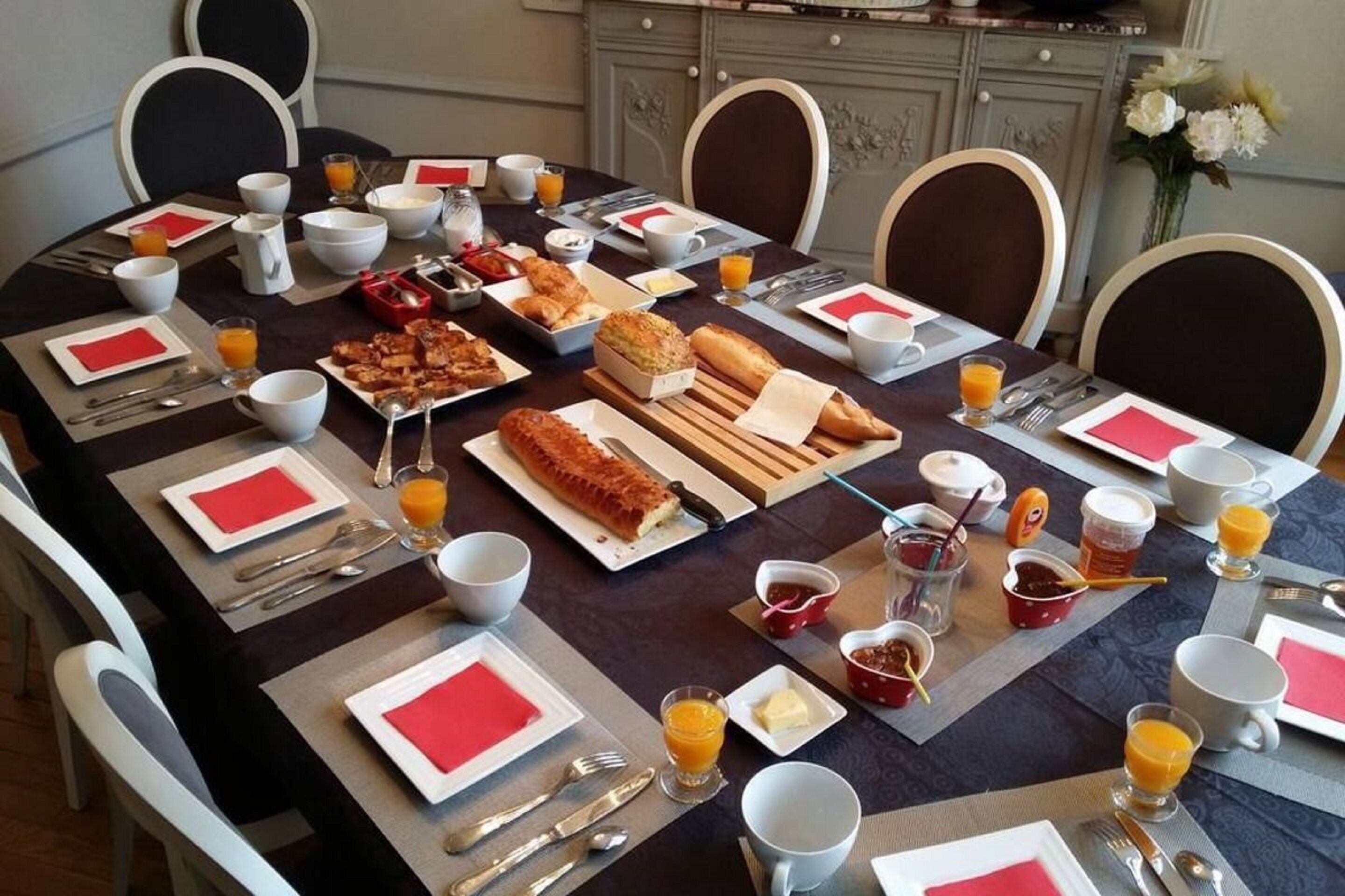 Una tavola imbandita per la colazione, con diversi piatti, posate e bevande.