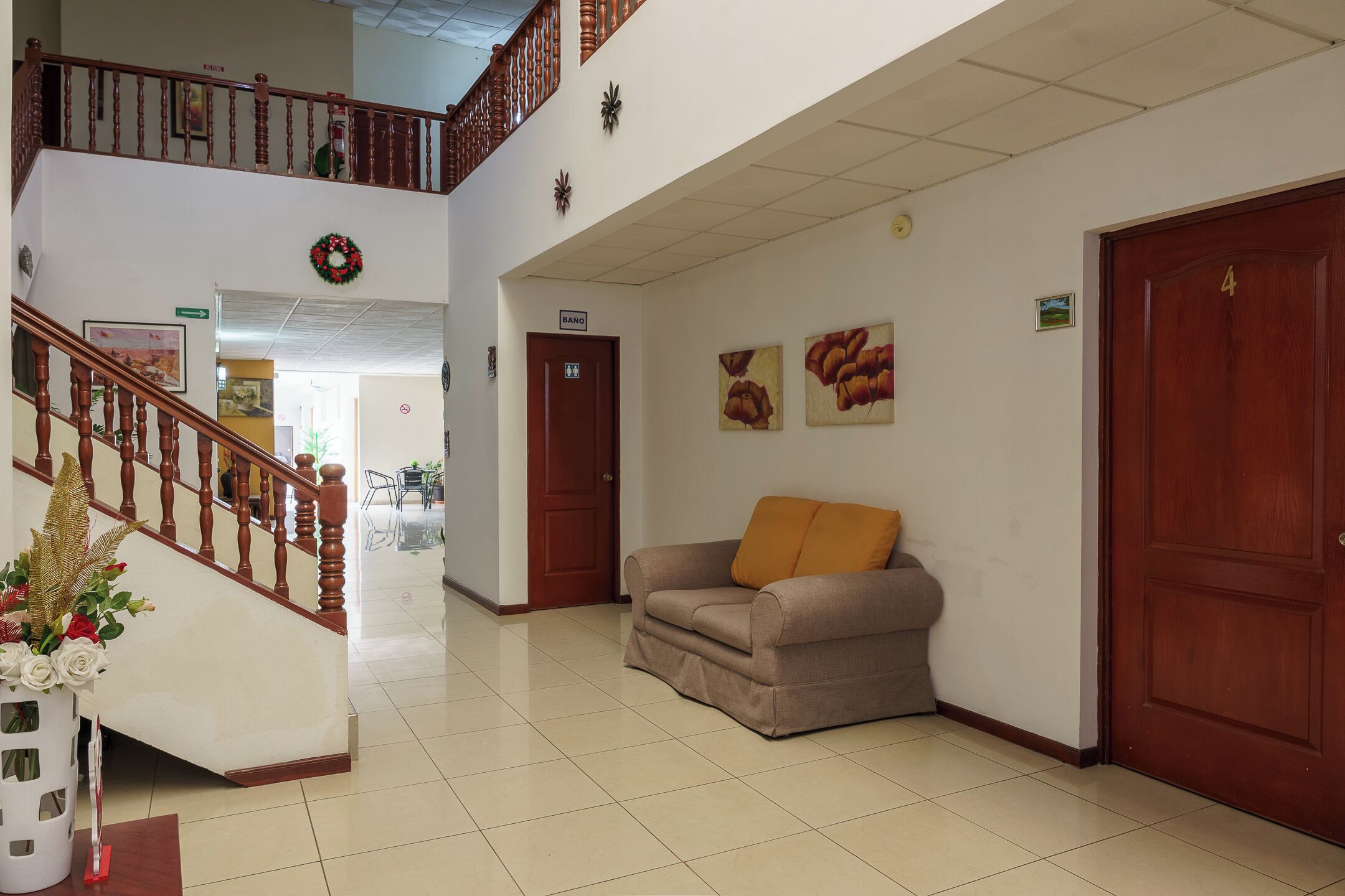 Un hall d’entrée avec un escalier, un canapé, une porte et des œuvres d’art murales.