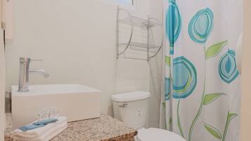A bathroom with a sink, toilet, and shower curtain.