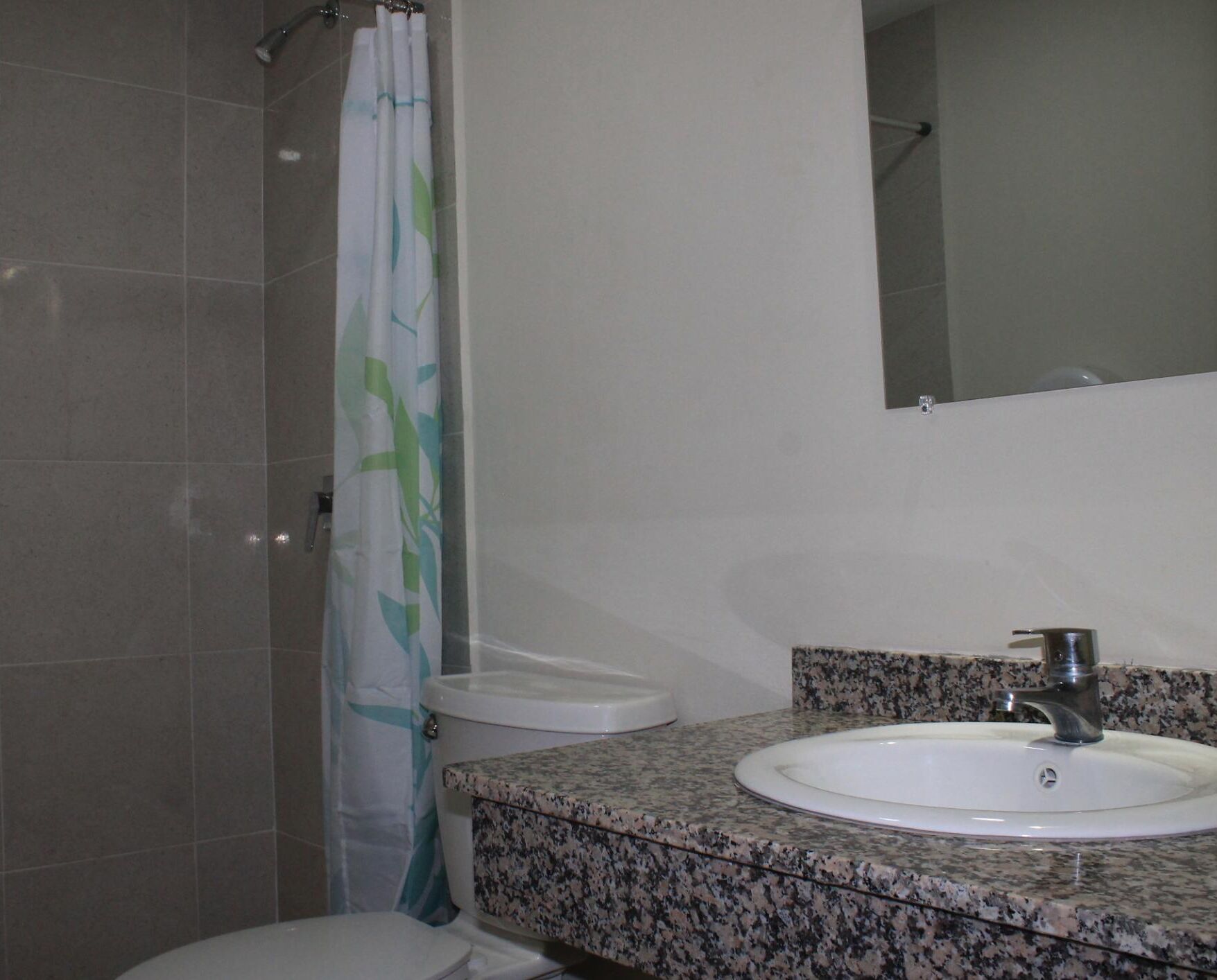 A bathroom with a shower, toilet, and sink.