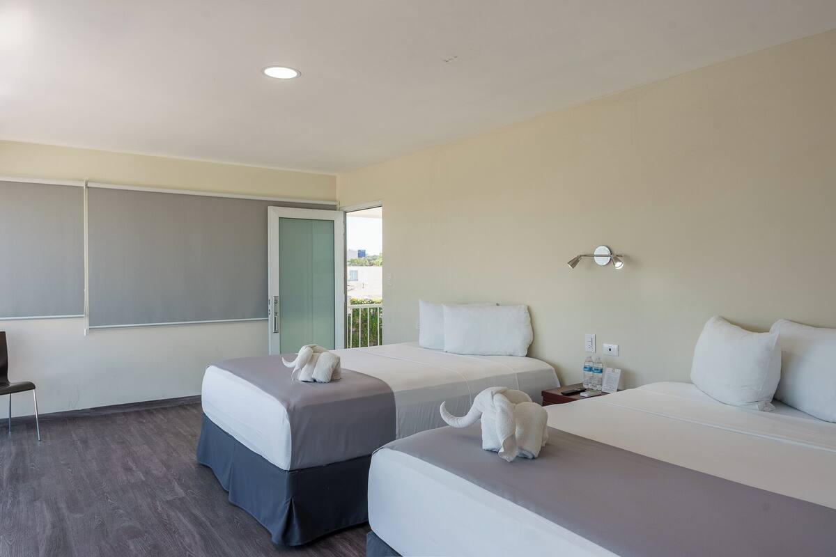 Una habitación de hotel con dos camas, un escritorio y una silla.