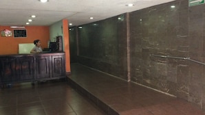 Ein Empfangsbereich mit einer Theke, einer an der Wand befestigten Speisekarte und einem Fliesenboden.
