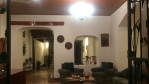 Un salón con suelo estampado, dos sofás, una mesa de centro y una araña.