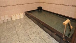 A bathroom with a bathtub, toilet paper, and a tiled floor. - Daienin (Koya)