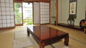 A traditional Japanese room with tatami flooring, a wooden table, sliding doors, and a framed artwork on the wall. - Daienin (Koya)