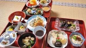 A traditional Japanese meal set on a tatami mat with various dishes including sushi, sashimi, and pickled vegetables. - Daienin (Koya)