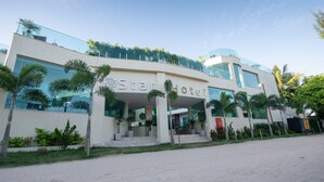 A modern hotel with a prominent 'Star Hotel' sign, large glass windows, and a well-maintained outdoor area with palm trees. - Star Hotel (Jijoca de Jericoacoara)