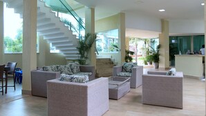 A spacious lobby with a staircase, wicker furniture, and potted plants. - Star Hotel (Jijoca de Jericoacoara)